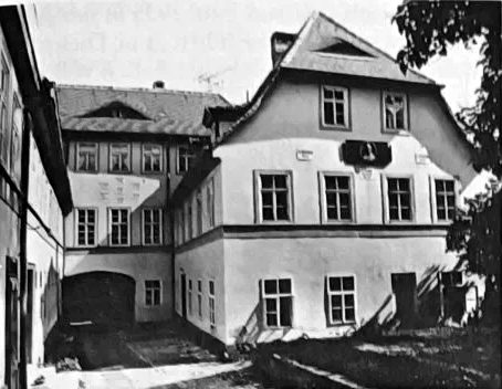 Zweigeschossiges Haus mit Satteldach und Hofeinfahrt
