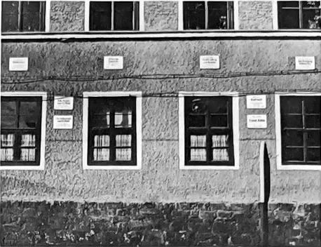 Hausfassade mit mehreren kleinen Gedenktafeln über und zwischen den Fenstern
